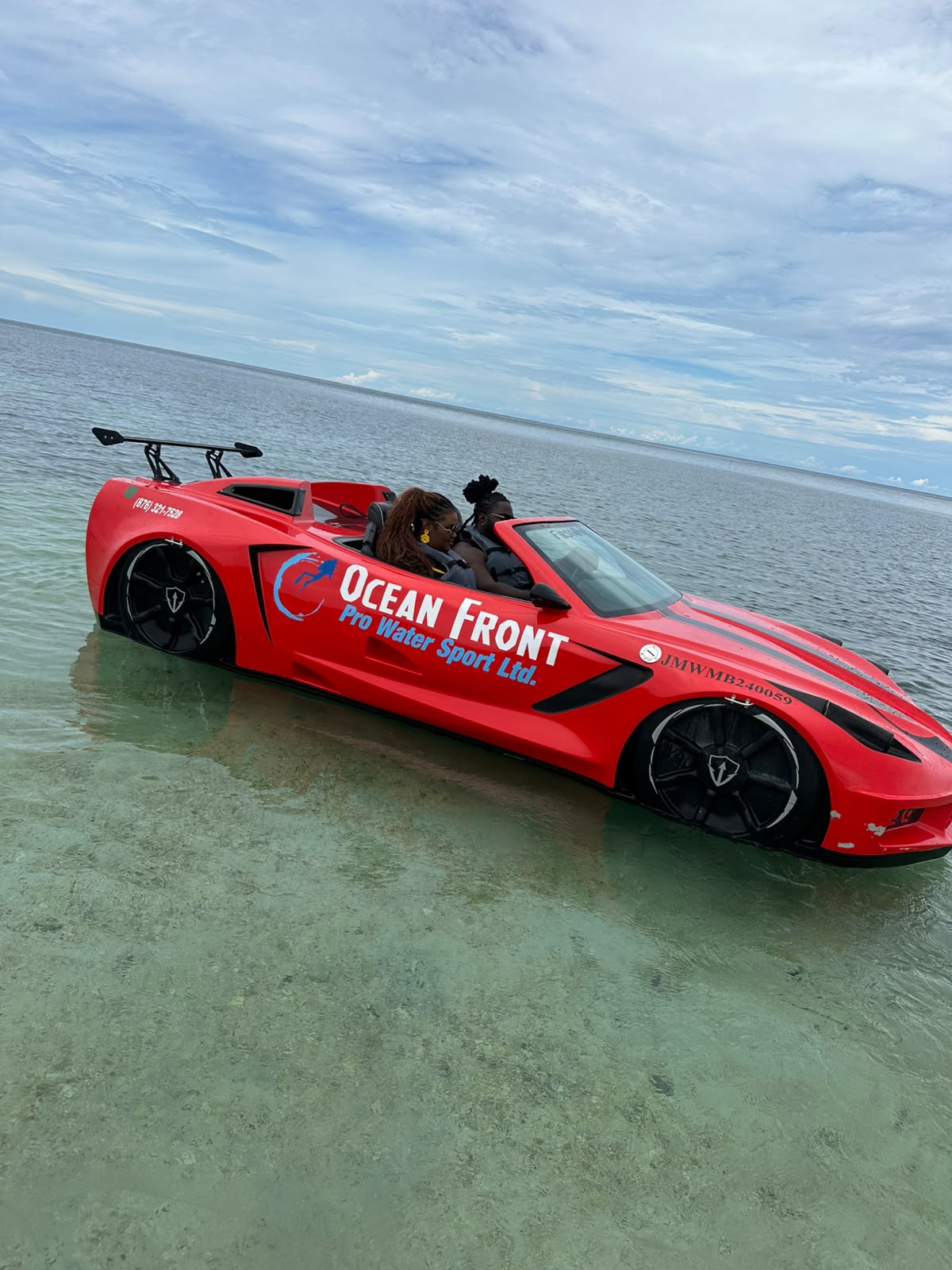 Red water car riding through shallow turquoise Caribbean water